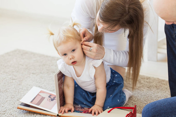 Hallókészülék a kislányok fülében. A kisgyerek otthon hord hallókészüléket. Fogyatékkal élő gyermek, fogyatékosság és süketség fogalma. - Fotó, kép