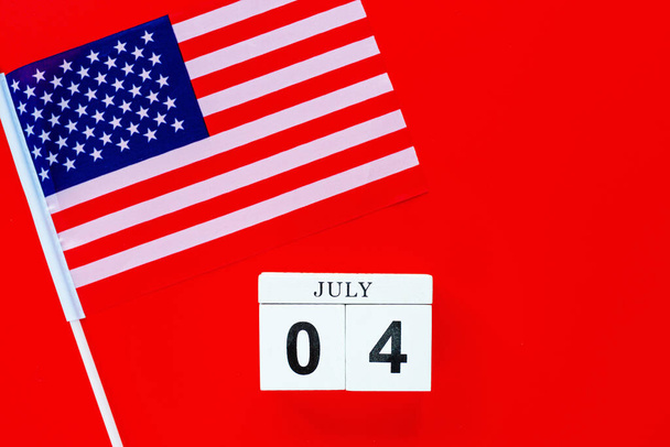 July 4th. Mockup of july 4 wooden color calendar on red background. Copy space for text. Independence Day Of America. Flat lay, top view, template. - Foto, Imagem