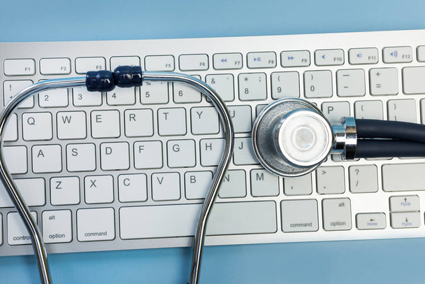 Stethoskop und Computertastatur. Computertechnologie ist heute ein integraler Bestandteil der Medizin, des Gesundheitswesens, der Medizin und der Krankenversicherung. - Foto, Bild
