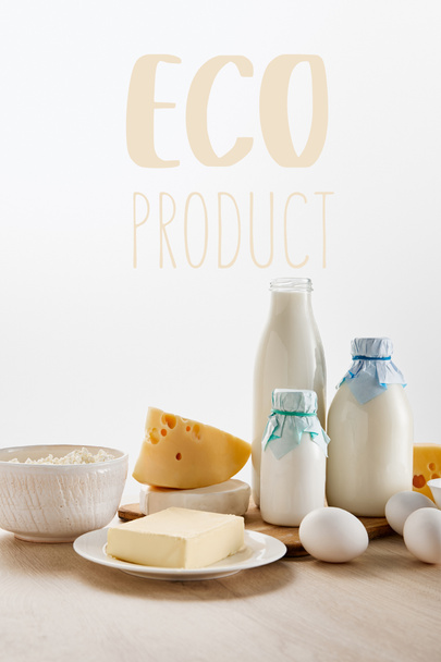 エコプロダクトイラストで白に隔離された木のテーブルの上の様々な新鮮な有機乳製品や卵 - 写真・画像