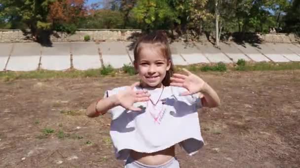 little girl in sportswear plays on the street - Footage, Video
