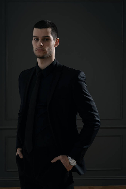Fiatal, jóképű üzletember fekete ingben és fekete öltönyben. - Fotó, kép