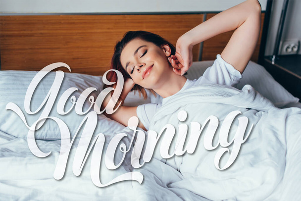 atractiva chica positiva que se enfría en la cama por la mañana durante el auto aislamiento con buen signo de la mañana
 - Foto, Imagen