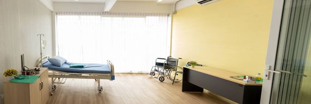 Hintergrund des Patientenzimmers mit Rollstuhl, Bett und dem Licht aus dem Fenster. Patientenzimmer Panorama - Foto, Bild
