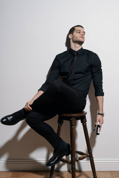 Young handsome businessman in black shirt and black suit - Fotoğraf, Görsel