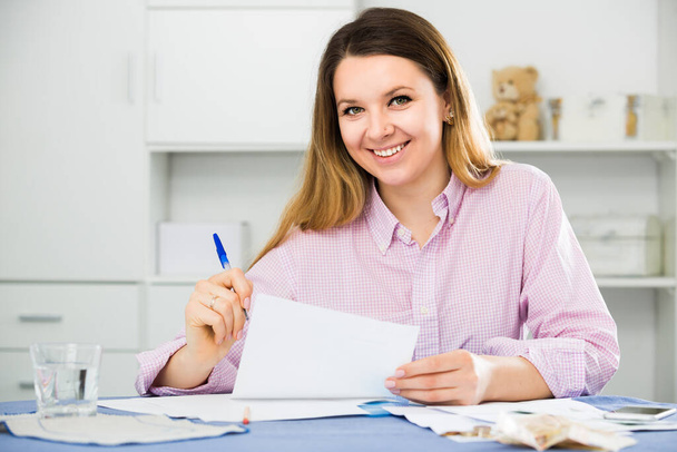 Woman is signing profitable financial agreement at home.  - Zdjęcie, obraz