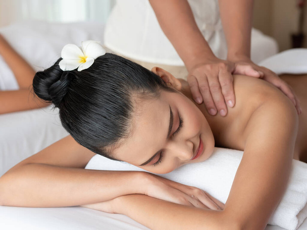 Aziatische vrouw ontspannen en glimlachen op bed matrassen in de Spa. Thaise massage voor de gezondheid. - Foto, afbeelding