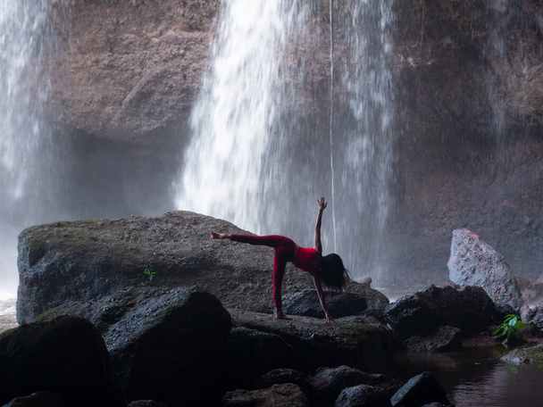 Asian woman practicing or doing yoga at the waterfall. Beautiful Landscape, Natural background, Thailand. - Photo, Image