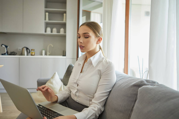 Attractive young businesswoman working on laptop in her home. Lockdown 2020, isolation and pandemic. Stay connected with technology. - Photo, Image