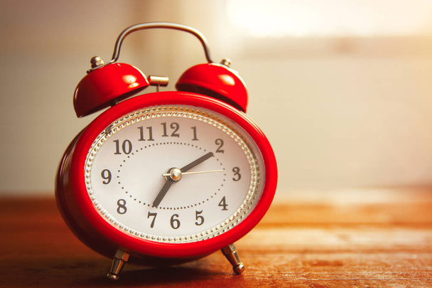 Red old style alarm clock on wooden background - Valokuva, kuva