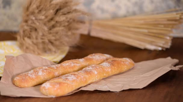 Vers gebakken Franse stokbrood op houten tafel. - Video