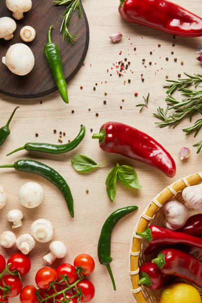 top view of delicious fresh ripe vegetables, herbs, spices and mushrooms on wooden table - 写真・画像
