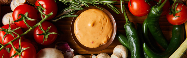 vista superior de la deliciosa salsa de tomate en un tazón cerca de verduras frescas maduras, romero y champiñones, plano panorámico
 - Foto, Imagen