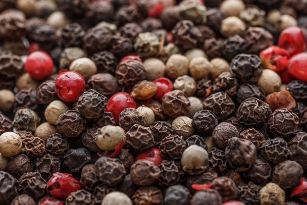 Close up of Mixted multi coloured peppercorns. white, black and green peppercorns macro background.Mixed peppercorns red black and white in bowl - Close-up. - 写真・画像