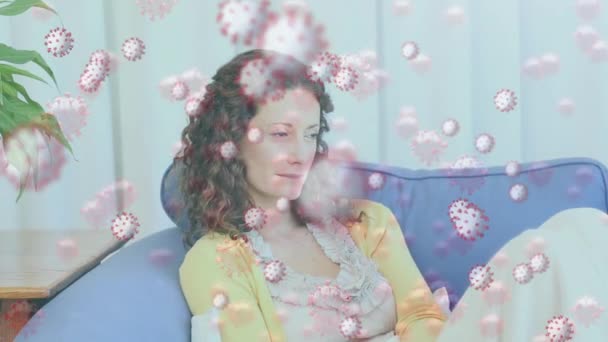 Animation of macro Covid-19 cells floating over Caucasian woman sneezing into a tissue. Coronavirus Covid-19 pandemic concept digital composite - Felvétel, videó
