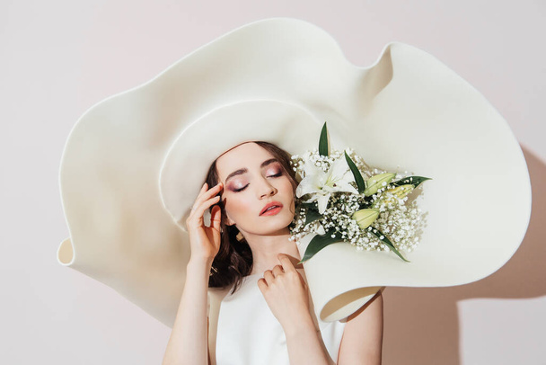 Роскошная невеста со шляпой и цветами в шляпе, мода
 - Фото, изображение