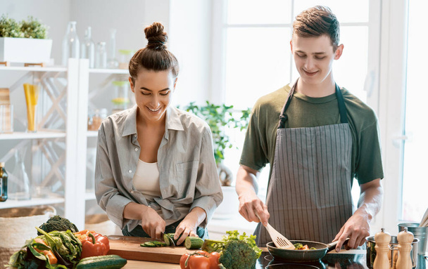 Healthy food at home. Happy loving couple is preparing the proper meal in the kitchen.  - Foto, Imagem