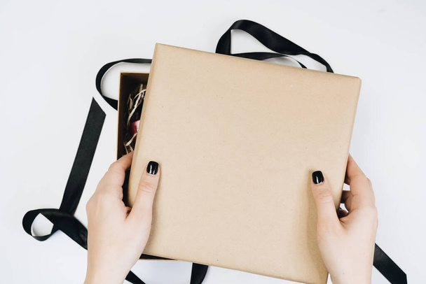 vista parcial de la mujer atando cinta en caja de regalo aislado en blanco
 - Foto, Imagen