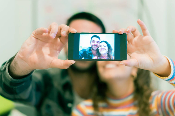 Zachycuji světlé momenty. Radostný mladý milující pár točí selfie před kamerou. Nové technologické trendy a koncepce přátelství - Obrázek. - Fotografie, Obrázek