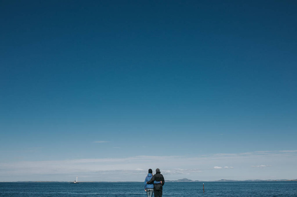 Noruega. La pareja se toma de la mano y observa el paisaje. Puesta de sol
. - Foto, imagen