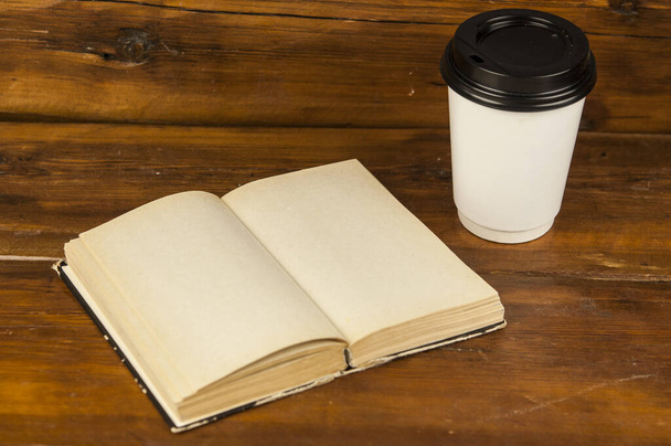 Taza de café y libro en el escritorio. - Foto, imagen