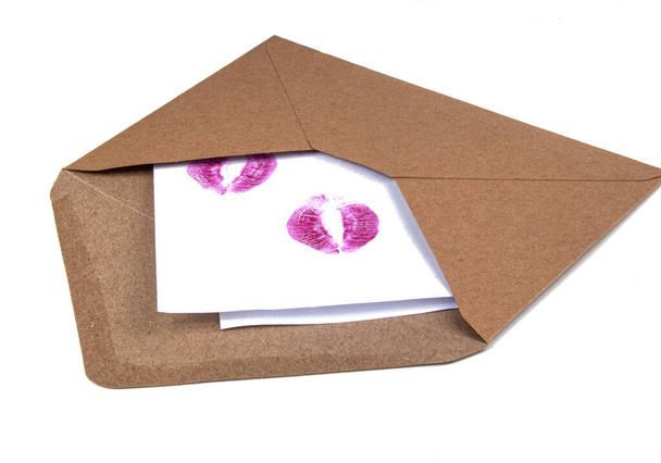 Enveloppe artisanale avec piste de baiser à lèvres isolée sur le blanc
 - Photo, image