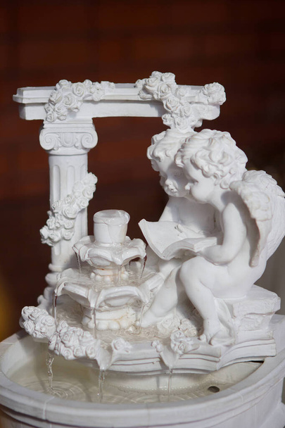 La figurine d'un petit ange parmi les décorations de l'occasion ou des fêtes
. - Photo, image