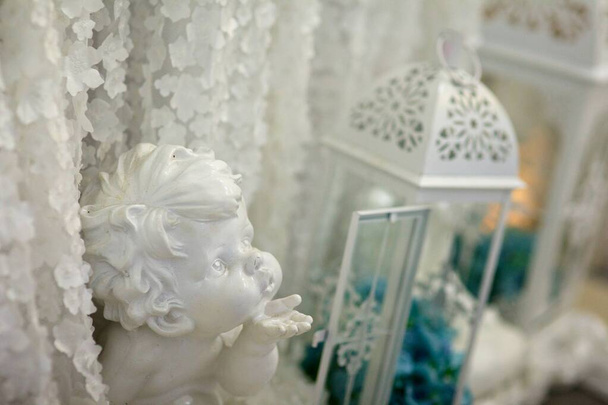 The figurine of a little angel among the decorations on the occasion or holiday. - Photo, Image