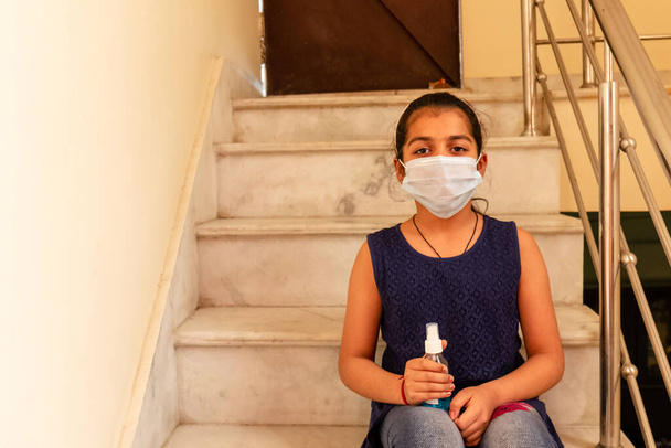 Mladá dívka nosí na tváři lékařskou masku a používá Sanitizer, aby zabránila virům a bakteriím. Koncept s barevným pozadím. - Fotografie, Obrázek
