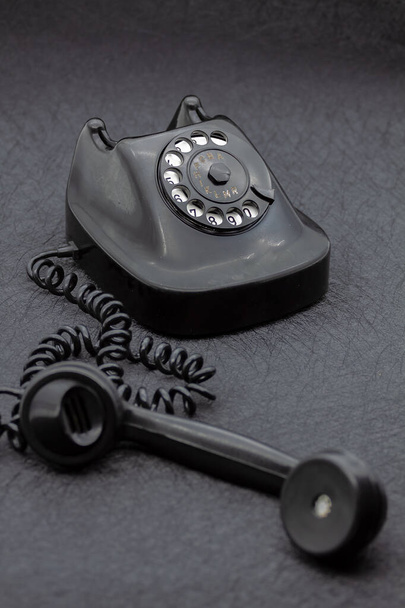 Vintage analogowy telefon bakelitowy w kolorze czarnym. Skupienie selektywne z płytką głębią ostrości. - Zdjęcie, obraz