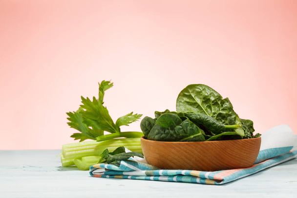 Spinach leaves in plate on light blue  table. - Photo, Image