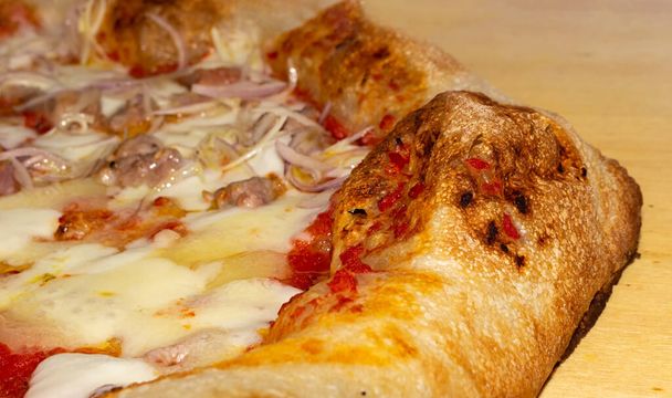 gros plan de pizza molle garni de mozzarella tomate saucisse salami oignon
. - Photo, image