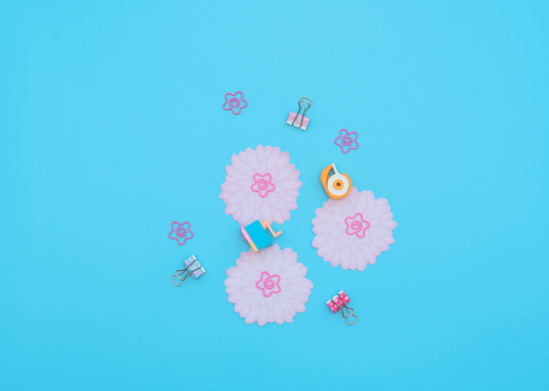 School and office supplies: clips, note paper, stickers, erasers on blue background. Back to school, stationary, mother day in office concept. Not boring set for work at office. Flat lay style. - Фото, зображення