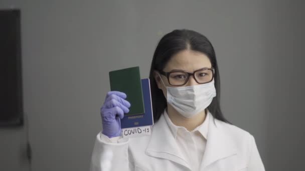 The doctor holds passports in his hand with tickets bearing the inscription COVID 19. Warning about the danger of travel during a pandemic. Hospital concept. Prores 422 - Materiał filmowy, wideo