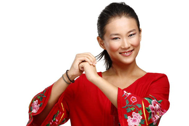 Chinese woman greeting gesture in elegant red dress - Valokuva, kuva
