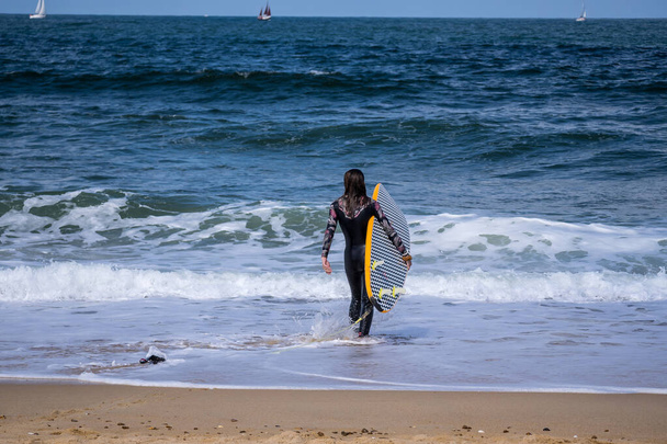 Denize sörf yapmaya giden bir kadın. - Fotoğraf, Görsel