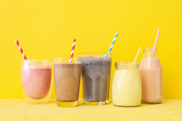 Delicious milkshakes on yellow background. Summer drink - Foto, imagen