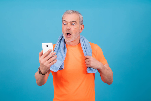 adulto ou idoso com sportswear e smartphone isolado em segundo plano
 - Foto, Imagem