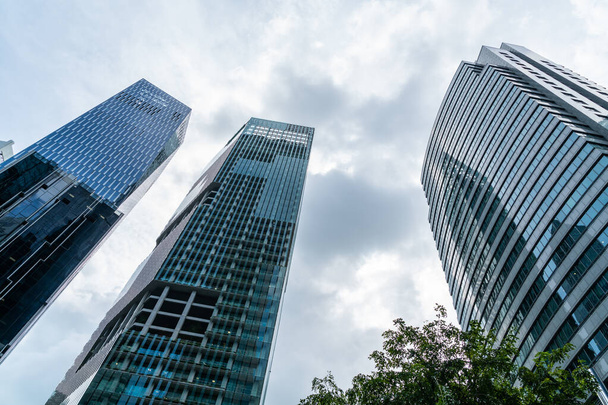 Alacsony látószögű kilátás festői felhőkarcolók Szingapúr belvárosában a nap folyamán. Pénzügyi negyed és kereskedelmi központ központ Ázsia régióban. A siker fogalma. Modern épületek a high-tech világban. - Fotó, kép