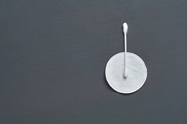 One clean cotton stick and pad lies on dark concrete desk. Space for text. Top view - Valokuva, kuva