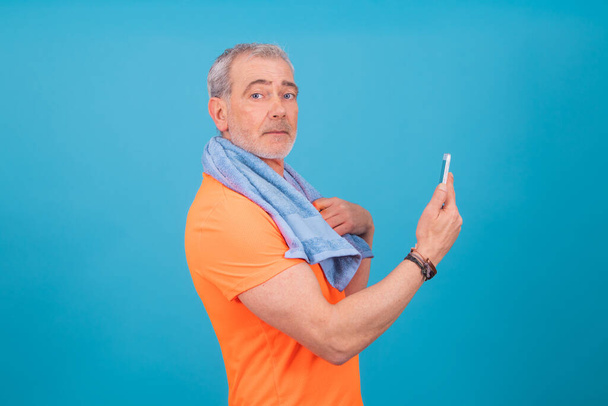 dorosły lub starszy mężczyzna z telefonu komórkowego i odzieży sportowej izolowane - Zdjęcie, obraz