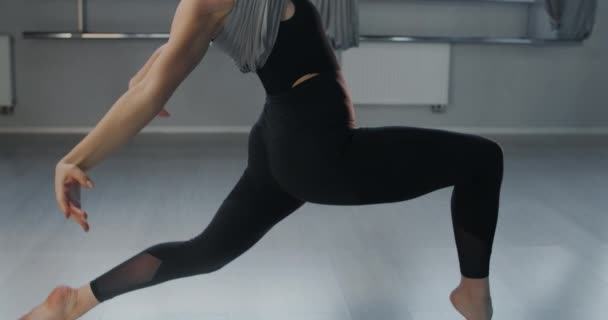 Çekici genç kadın sinekle yoga hamağını yavaş çekimde geriyor, esnek kadın akrobatik ve plastik egzersizler yapıyor, yoga ve esneme, 4k DCI 60p Prores 422 - Video, Çekim