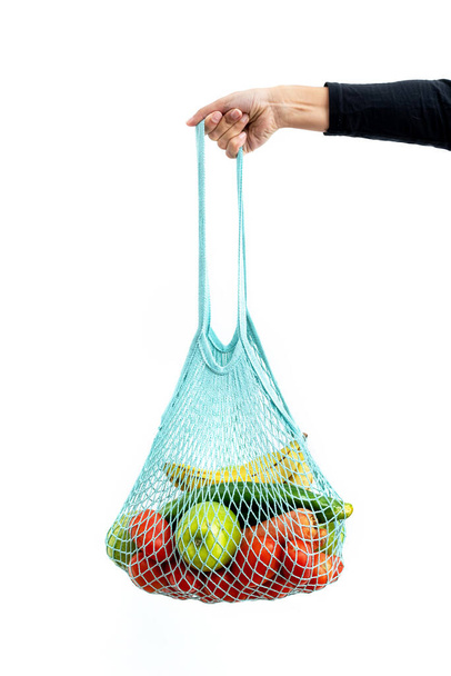 Girl holding reusable mesh bag full of organic vegetables - Photo, Image