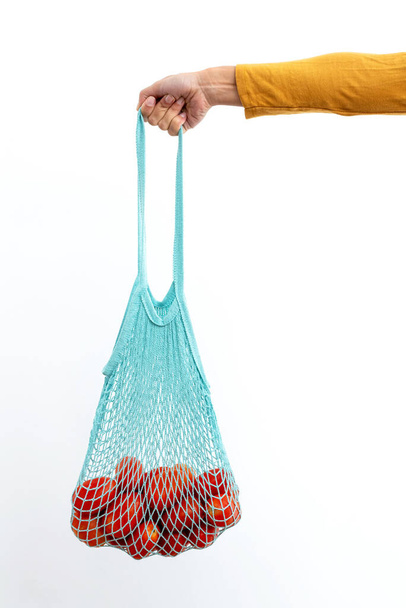 Ragazza in possesso di borsa riutilizzabile stringa piena di pomodori biologici
 - Foto, immagini