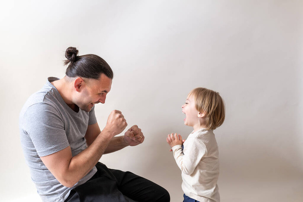Giovane padre boxe con il suo piccolo figlio su sfondo bianco studio
 - Foto, immagini