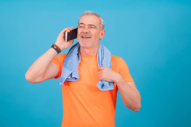 чоловік з мобільним телефоном і спортивним одягом ізольований на кольоровому фоні
 - Фото, зображення
