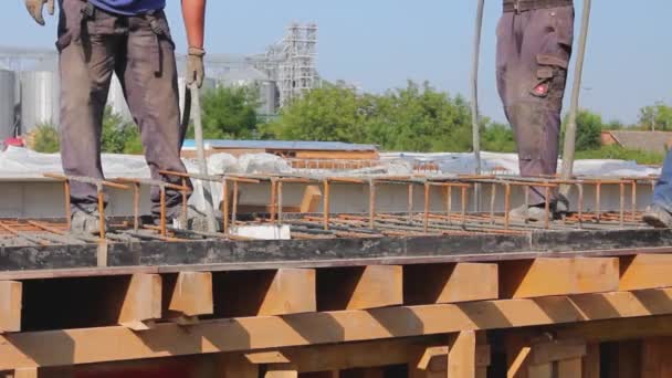 Stavební dělník používá elektrický nástroj, kompresor, při betonování v dřevěné plísni s ocelovým rámem uvnitř. - Záběry, video