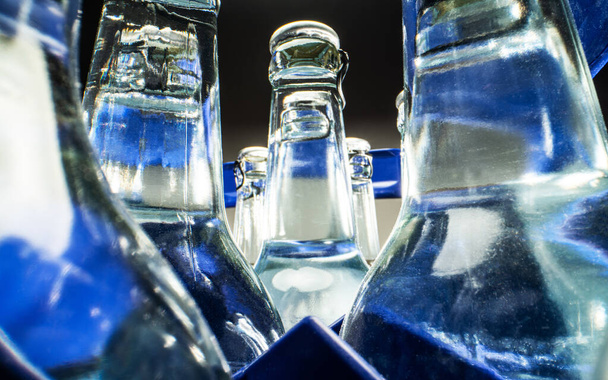 Close Up Of Blue Case Of Transparent Glass Bottles Filled With Mineral Water.  - Foto, Bild