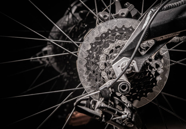 Gros plan de roue arrière de vélo avec la chaîne et les engrenages de pointes de disques métalliques
.  - Photo, image