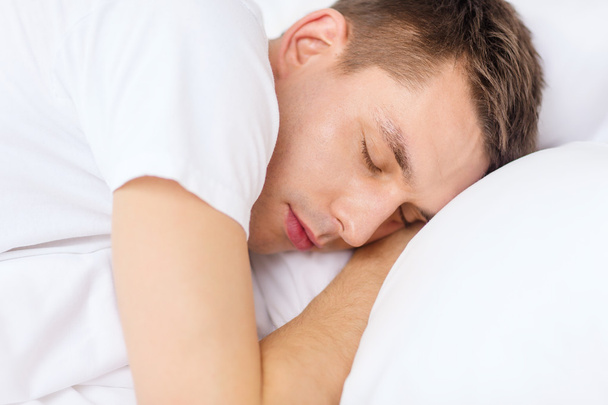 Komea mies nukkuu sängyssä
 - Valokuva, kuva